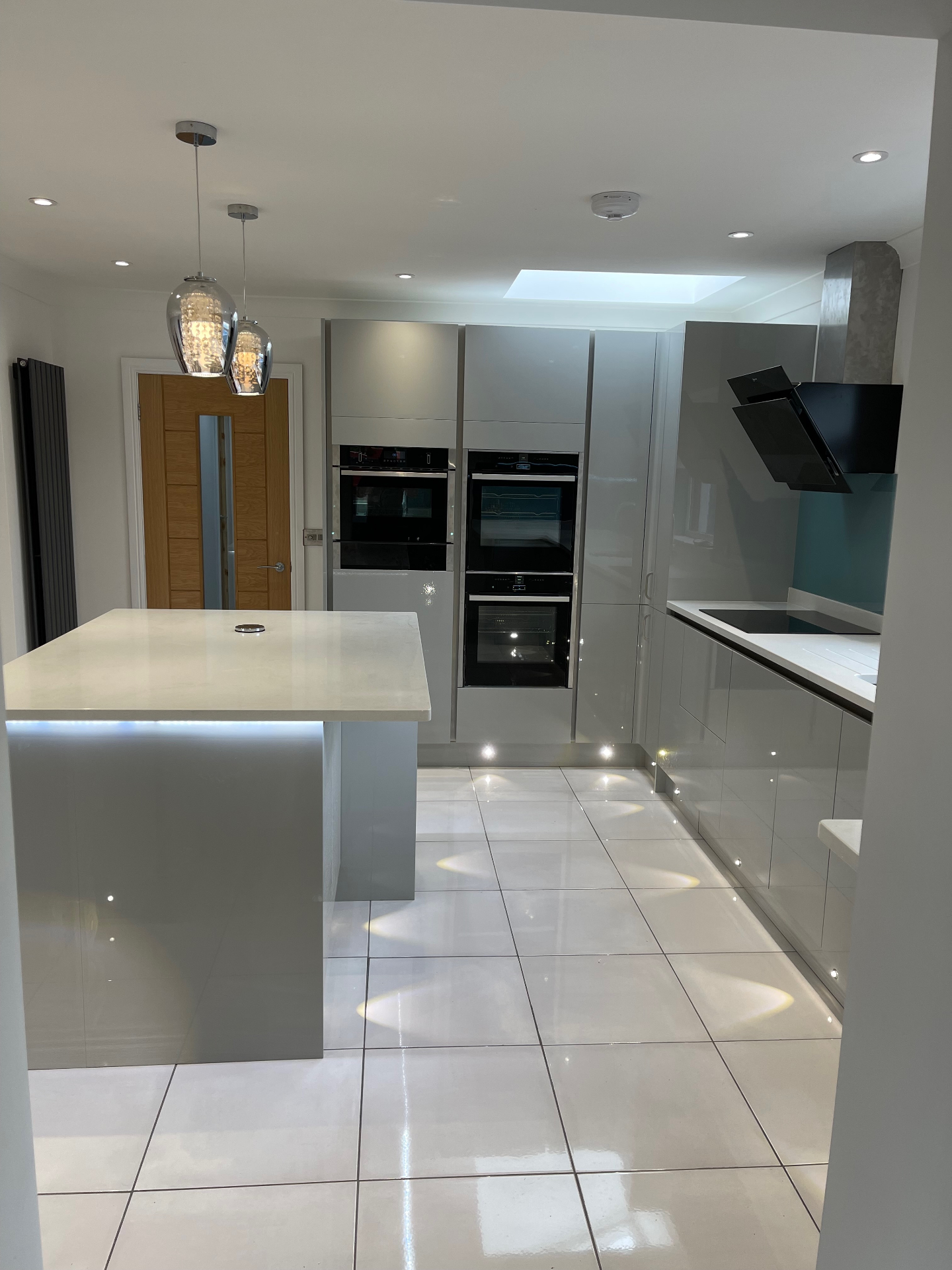 Grey gloss kitchen with downlights, pendants and plinth LEDs